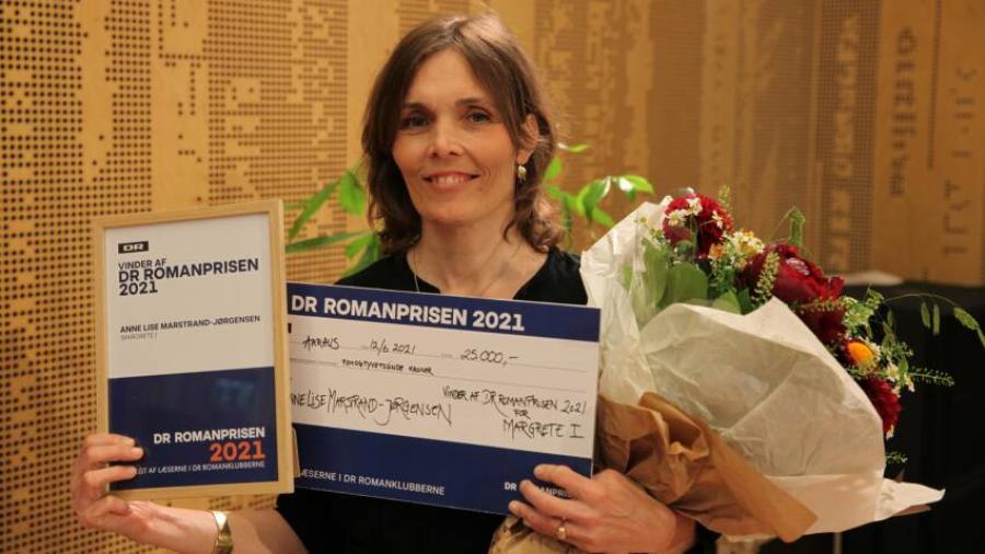Foto af Anne Lise Marstrand-Jørgensen med DR-Romanprisen 2021 i hånden